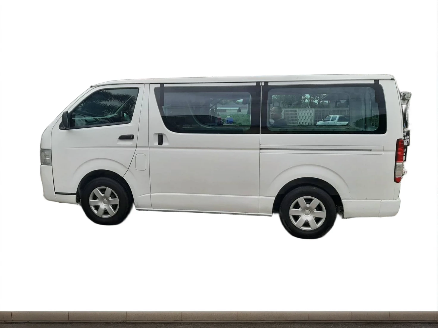 A white Arafa van is parked in a square with buildings in the background., Vehicle profile, มุมมองfrontด้านข้าง, 3/4 มุมมองfront, 3/4 side view, new vehicles, side view, Microbus, โปรไฟล์front, from the side, The car is full., front, side view, front full, front side view, snake from, Side - view. Behind is a mountain.