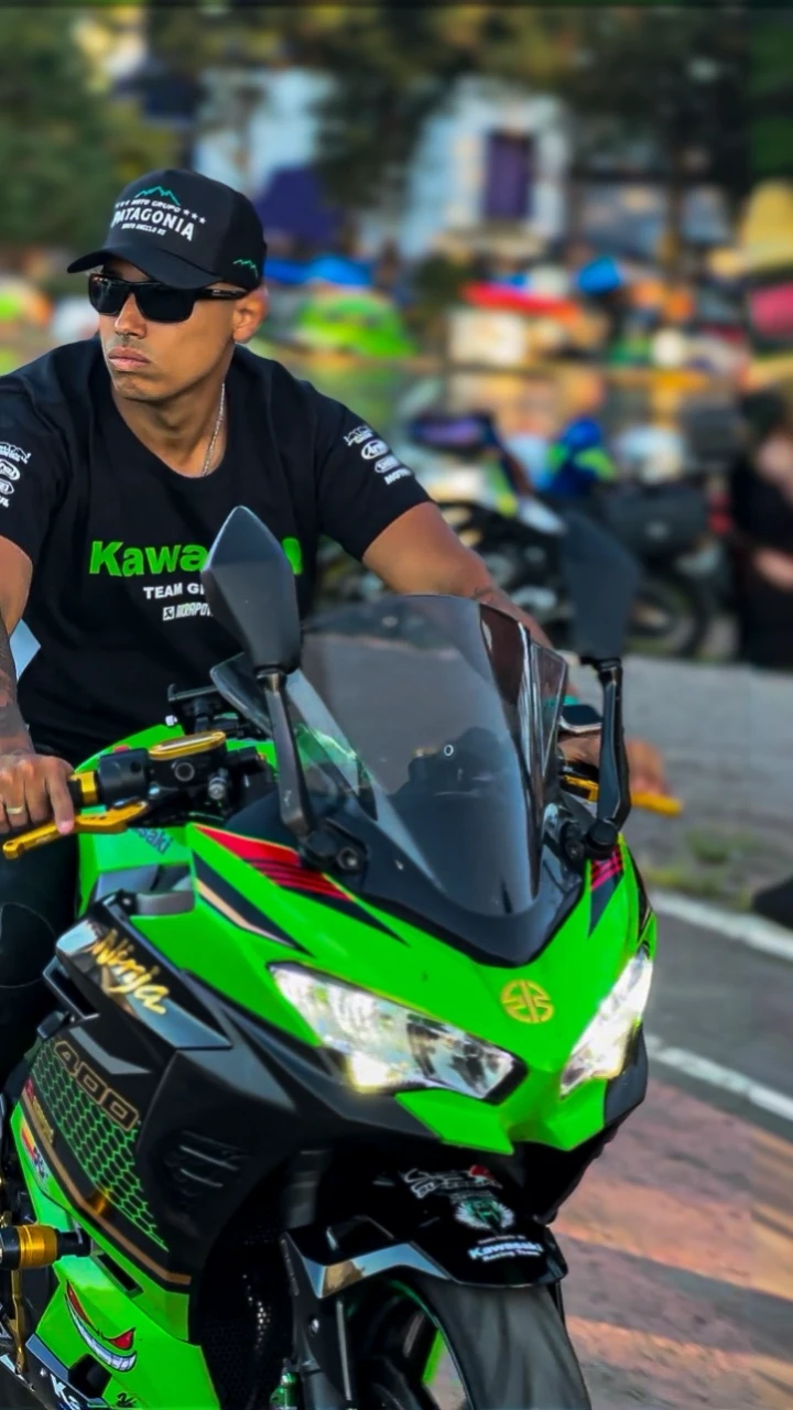 Man riding a Kawasaki ninja motorcycle at a motorcycle event