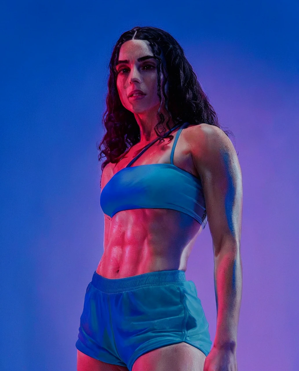 Woman, 27 yeats old, perfect abs, white skin (sweating after the dance workout), curly long hais (black hairs:1.4), (wearing fitness shorts and sport bra), 