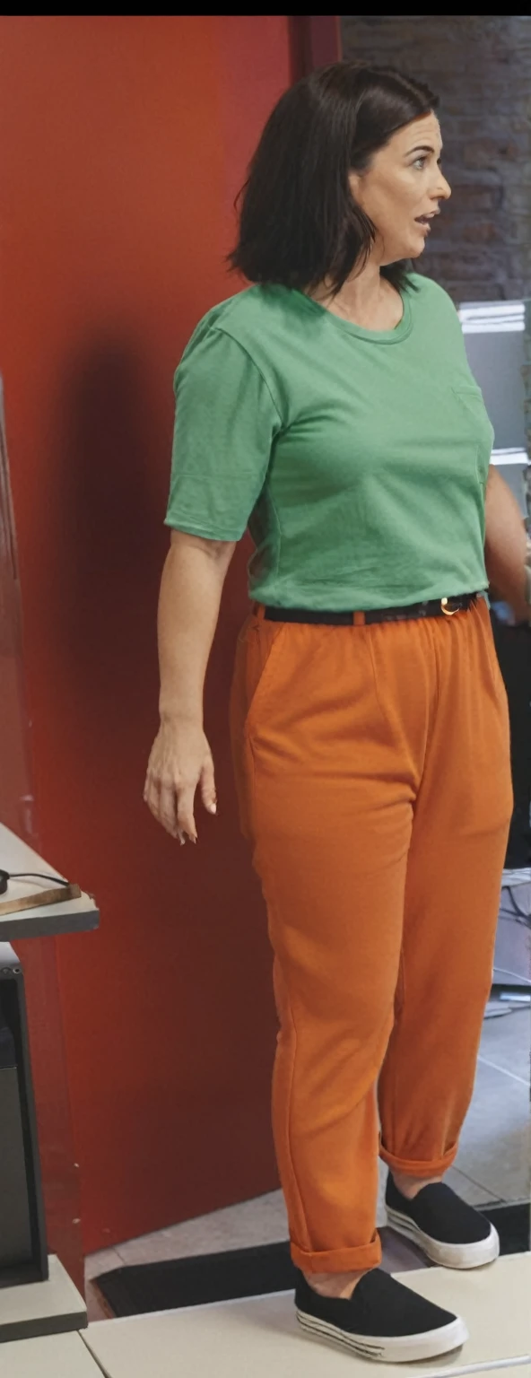 there is a woman standing in front of a computer screen, red shirt brown pants, wearing an orange t-shirt, wearing an orange t shirt, wearing pants and a t-shirt, middle shot waist up, wearing pants, wearing an orange jumpsuit, wearing orange prison jumpsuit, orange fluffy belly, vibrant but dreary orange, hand on hips, large pants