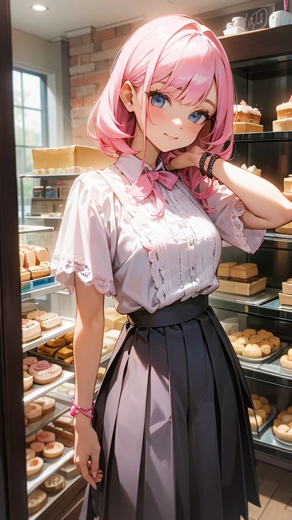 A woman with pink tousled hair, wearing a white lace blouse with short sleeves and black pleated skirt, posing in front of a window with a display of baked goods behind her. Her look is relaxed yet stylish, with a layered bracelet on her wrist.