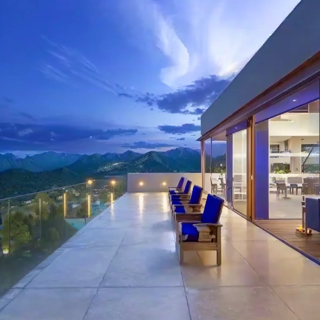 view of a patio with table and chairs overlooking a mountain, wide sight, contemporary masterpiece, paradise in the background, panoramic view at night, sit by the pool, beautiful view, architectural photo, beautiful and spectacular twilight, expansive cinematic vision, sunset view, Beautiful terrace, Incredible view, nice view, time to relax. good view