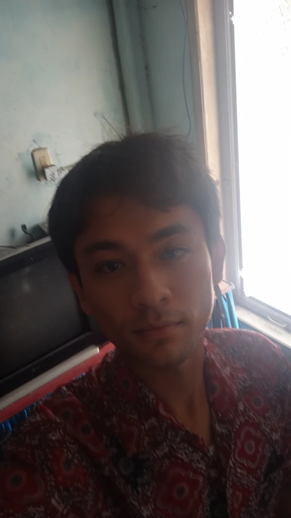 there is a young boy sitting in a chair with a remote control, ayan nag, nivanh chanthara, with accurate face, very very low quality picture, around 1 9 years old, blurry image, 18 years old, face picture, old picture, selfie photo, with kind face, riyahd cassiem, 1 6 years old
