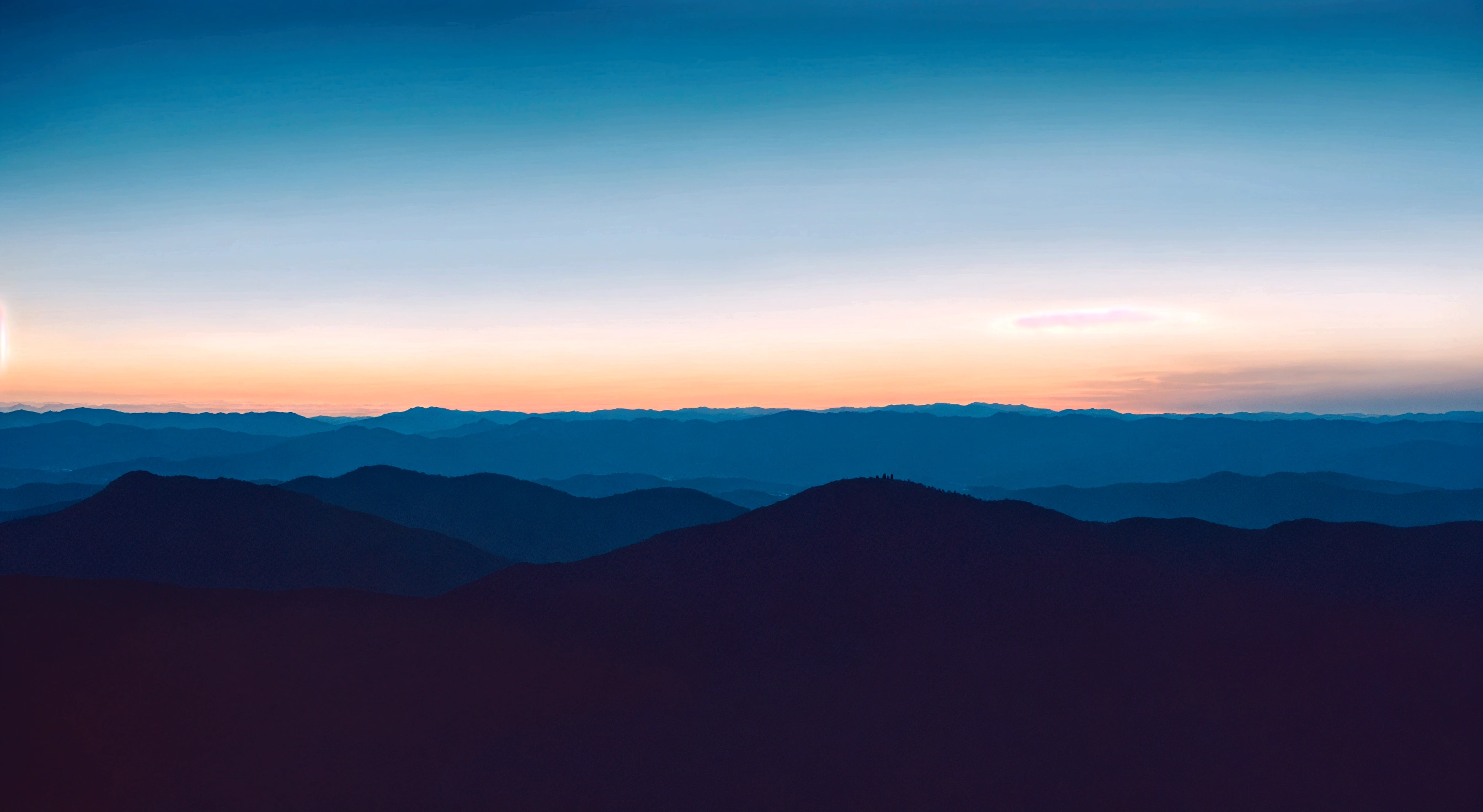 A beam of red light Between the skyline and the even mountain range