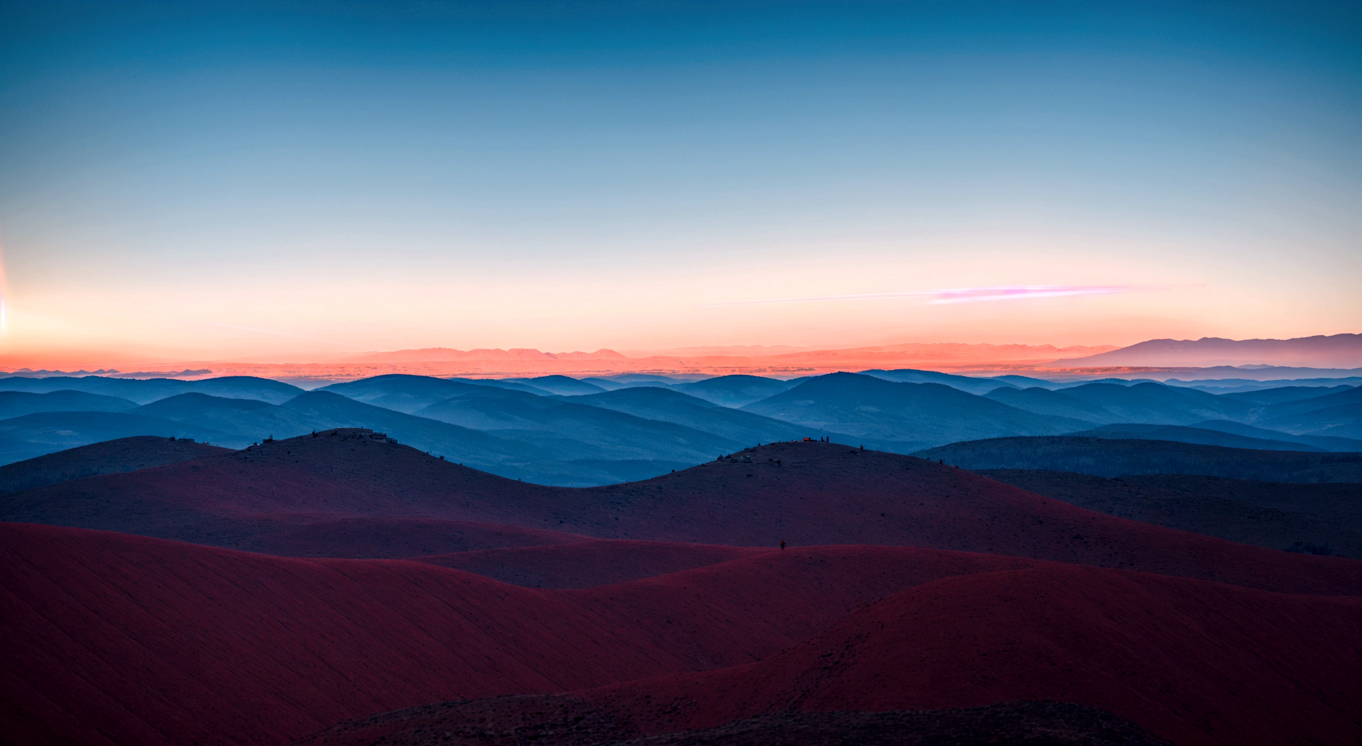 a vibrant red beam of light splitting the distant sky and a flat horizon, between the skyline and the even mountain range, with a dramatic atmosphere, a shine red line