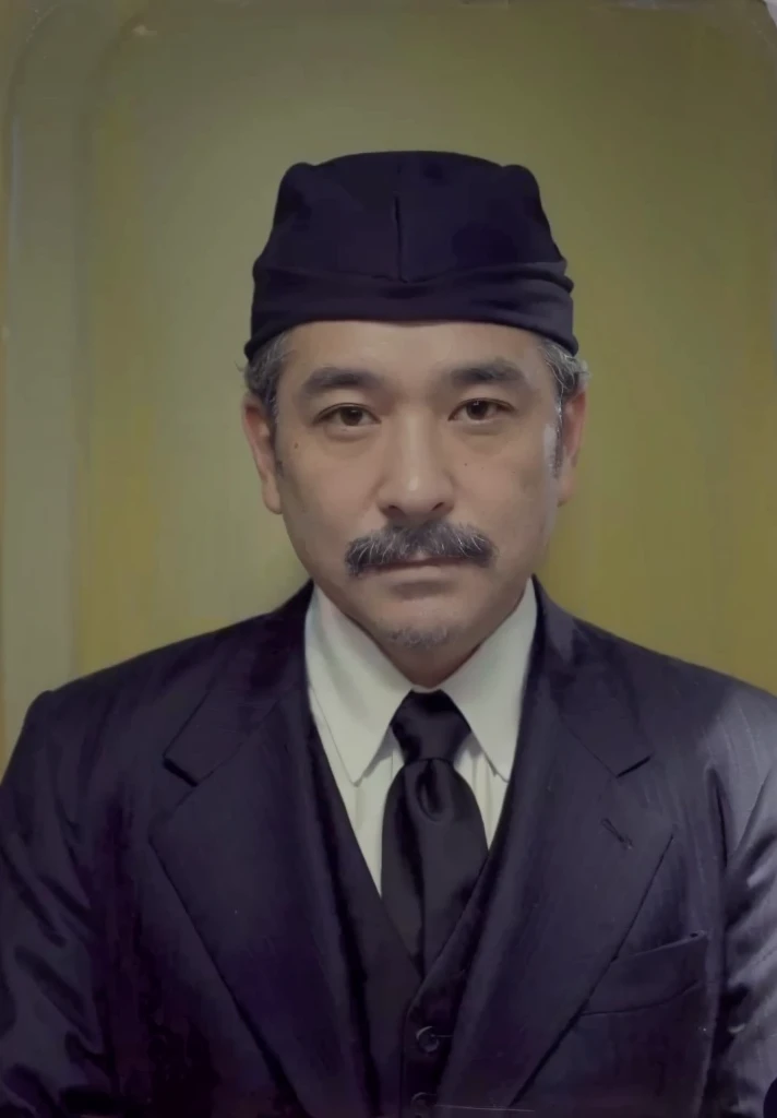 portrait of a 45 year old man wearing a black skullcap with a black suit