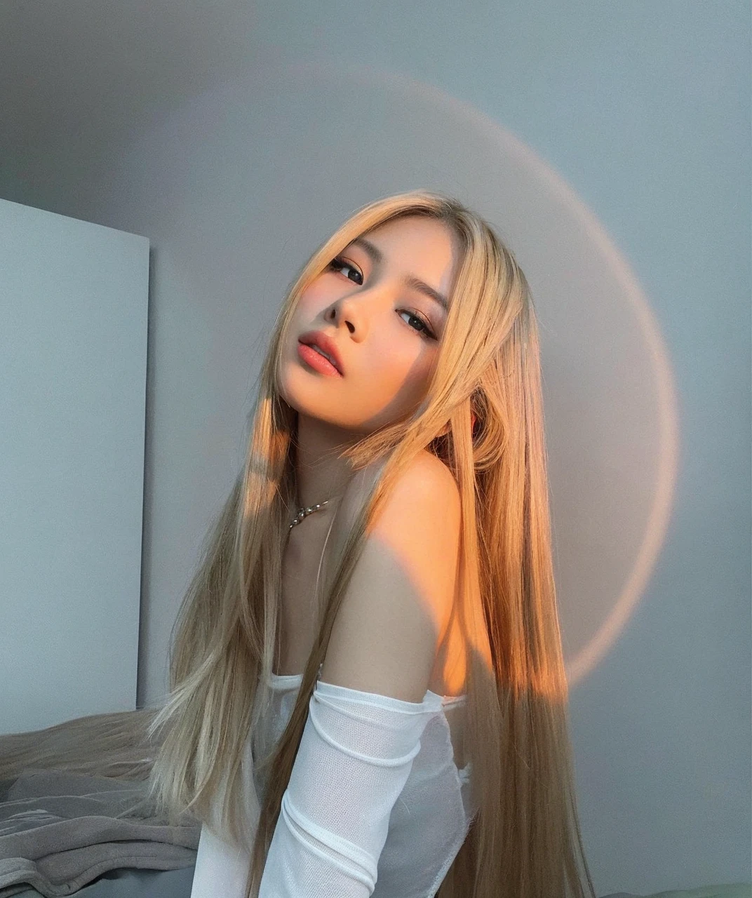 Asian model girl with blonde hair, fair skin and large black expressive and engaging eyes. Her features are delicate, with subtle cheekbones, a small nose and full, rosy lips. Her expression combines sweetness and seduction, resulting in a cute, sexy and beautiful appearance.