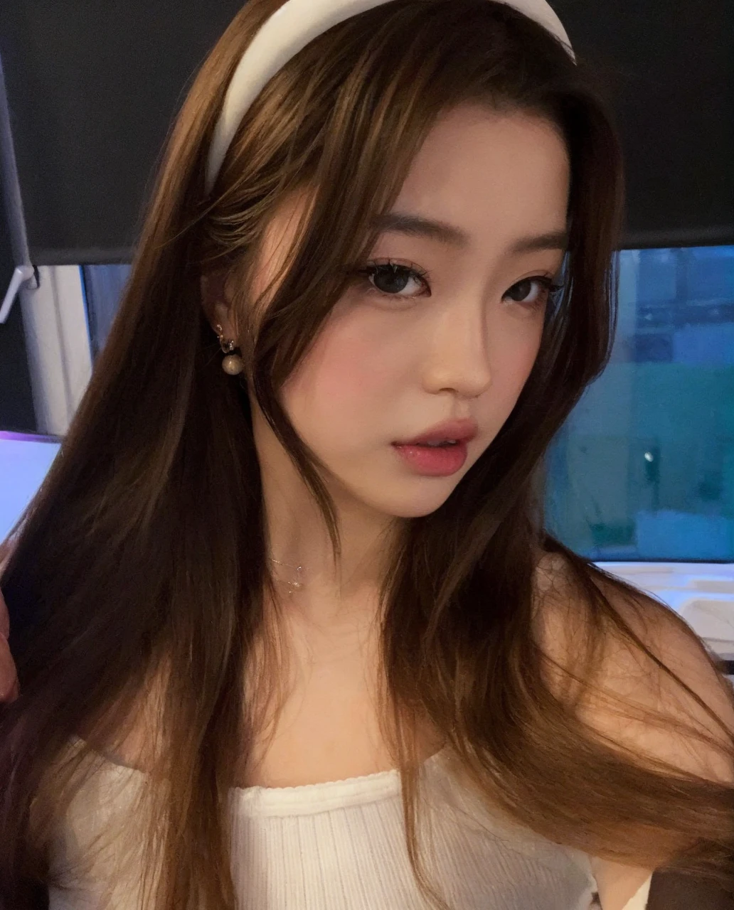 Asian model girl with blonde hair, fair skin and large, black, expressive and engaging eyes. Her features are delicate, with subtle cheekbones, a small nose and full, rosy lips. Her expression combines sweetness and seduction, resulting in a cute, sexy and beautiful appearance.