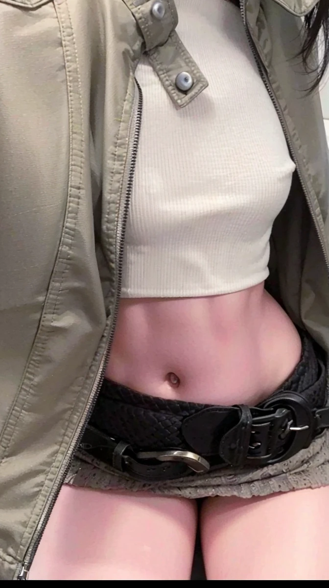 there is a woman with a belt around her waist, navel showing, her navel is exposed, transferred navel, visible belly, drilling, accentuated hips, exposed belly, visible stomach, tiny waist, transferred, smallest waist ever, Physicist : the smallest abdomen ever seen, exposed waist, jacket over bare torso