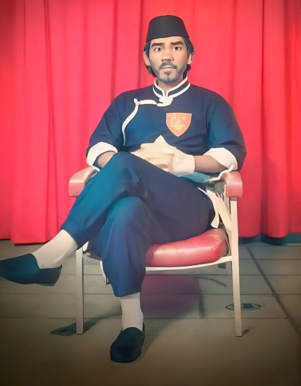 Realistic 3D caricature image of a full body Indonesian man sitting on a chair with a red curtain background. He is wearing traditional Chinese clothing, long-sleeved black cheongsam (sleeves rolled up to the elbows), shirt edges with white stripes on the edges and sleeves, shirt collar edges with stripes white. He wore a black skullcap. His hands were folded in his lap. He wore plain black joggers, white socks, and black traditional Chinese slip-on shoes (Wing Chun shoes) that matched his outfit. The man wore a calm and serious expression. The chair he sat on was red, possibly made of cloth or foam, with red armrests. He sat with his legs crossed, left leg over right. The backdrop features bright red curtains that stretch from top to floor. The floor visible below has a tile pattern, perhaps ceramic or tile, with some visible stains or dirt. Detailed HD quality cinematic 3D rendering.