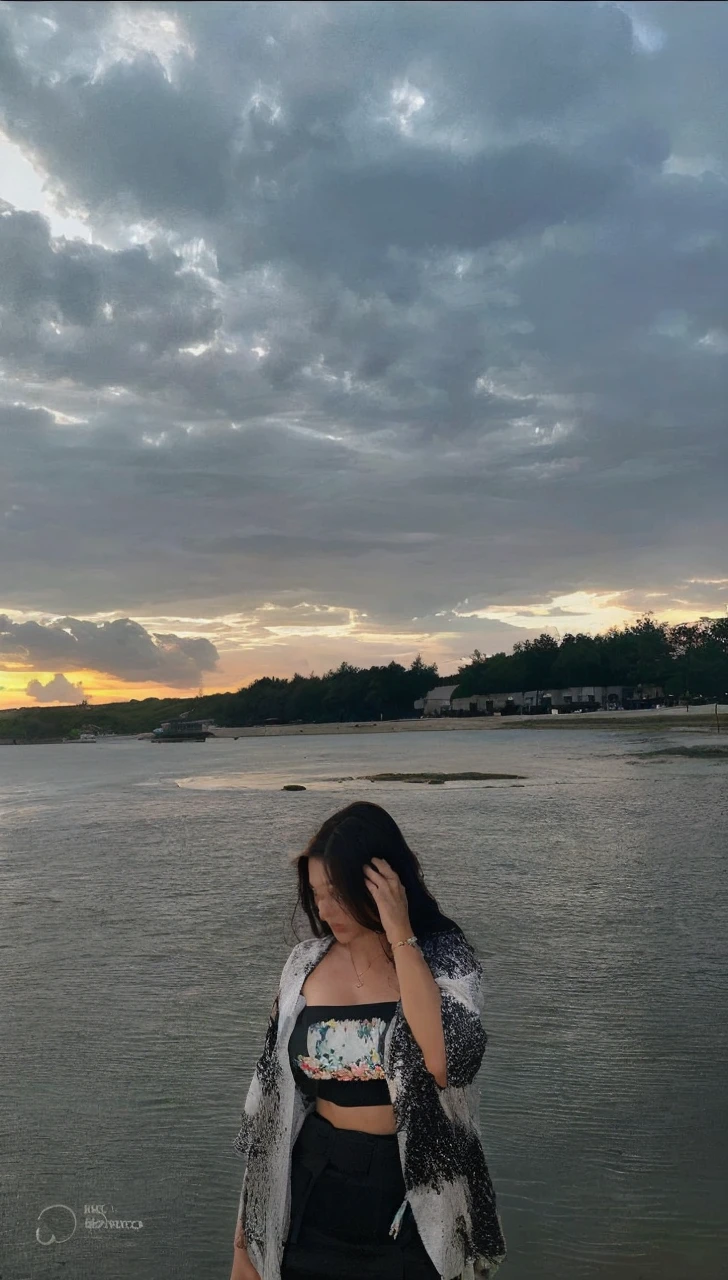 (Best quality, High resolution, Masterpiece :1.3), A tall and pretty woman, Slender abs, Dark brown hair styled in loose waves, Breasts, Wearing pendant, White button up shirt, Belt, Black skirt, (Modern architecture in background), Details exquisitely rendered in the face and skin texture, Detailed eyes, Double eyelid