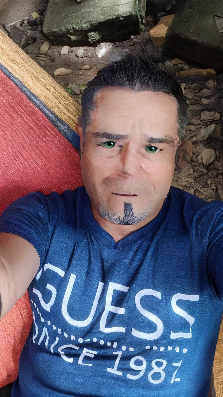 45-year-old man, short gray hair, green eyes, working in front of the computer, with an expression of astonishment at what he is seeing, white t-shirt with a green blouse, in the background we can see shelves with miniature cars. There is a cell phone on the table that is ringing.