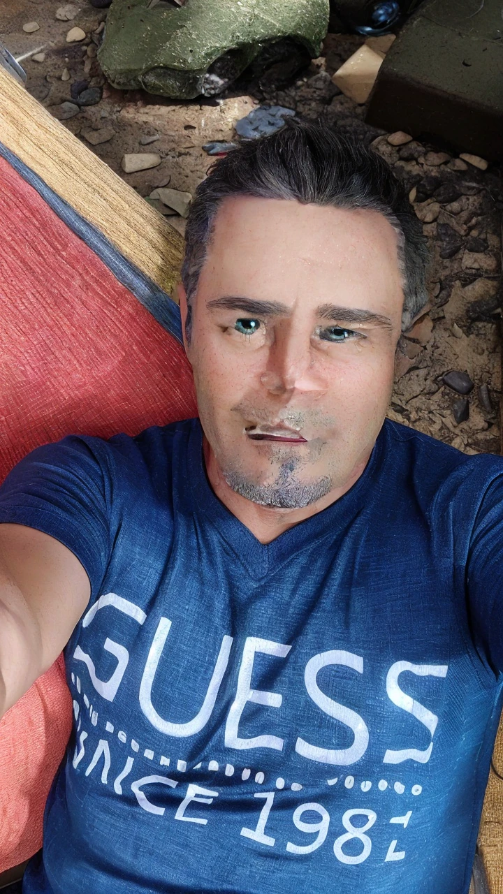 45-year-old man, short gray hair, green eyes, working in front of the computer, with an expression of astonishment at what he is seeing, white t-shirt with a green blouse, in the background we can see shelves with miniature cars. There is a cell phone on the table that is ringing.