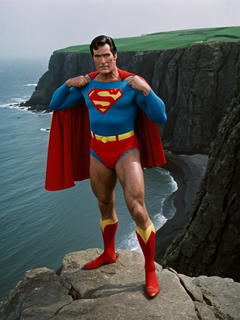 1970s, cold, cloudy sky, 70-year-old Superman, very broad shoulders, very protruding chest, very thick neck, arms and thighs that have gained fat, no abs, dull colored Superman costume, Superman mark spread out to the sides, small red briefs bulging, cape fluttering in strong wind, standing on a cliff