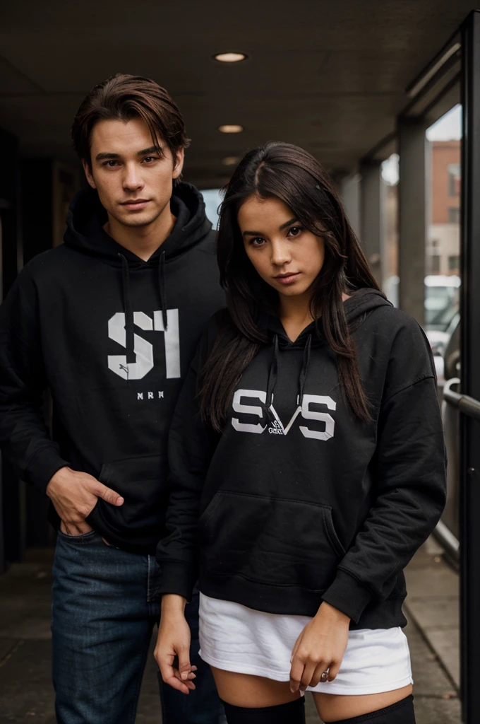 The girl wears a black hoodie that says S and the guy wears a black hoodie that says D