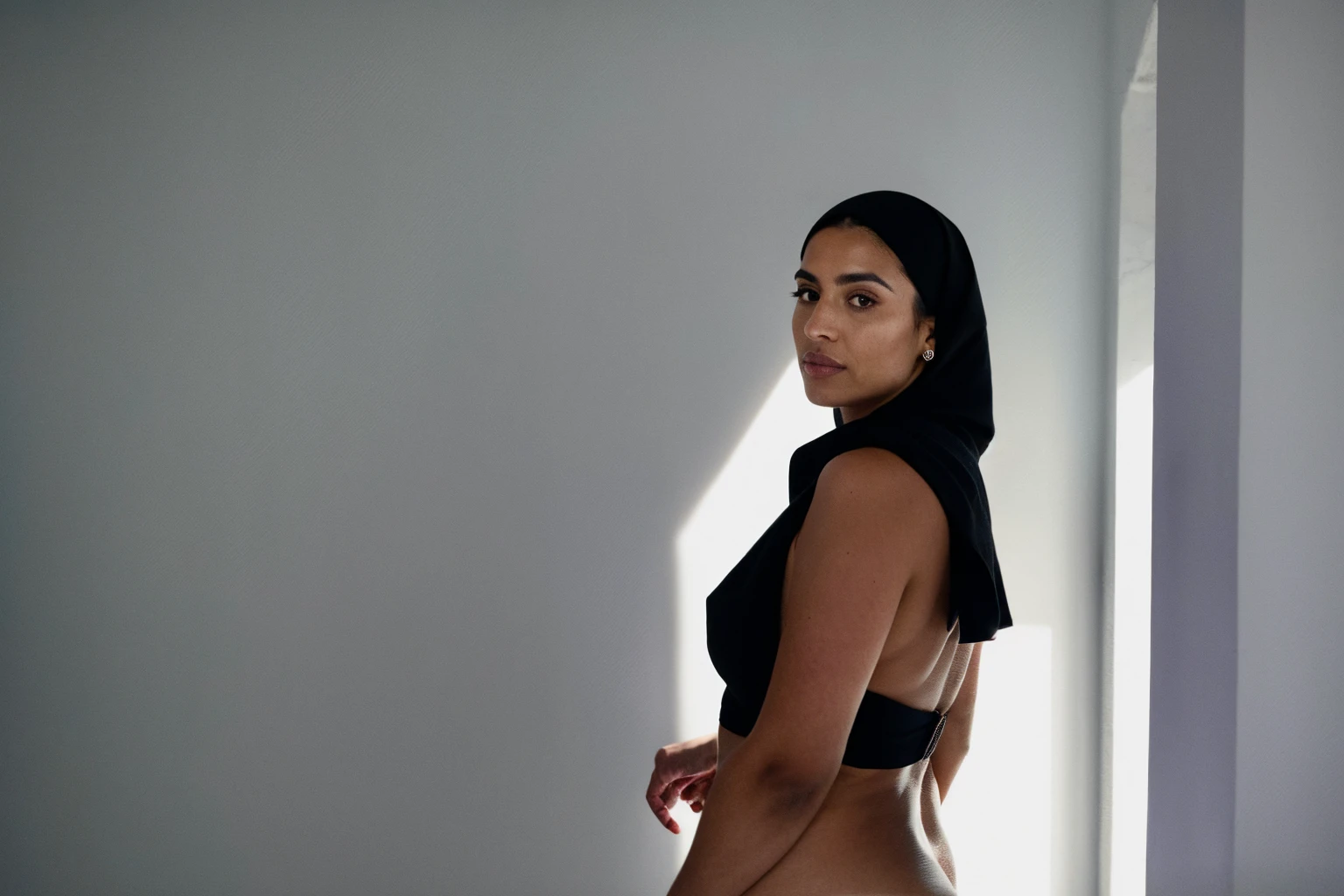 RAW photo,dark,moody,35mm focal lenght,underexposed,cold,candid photograph,artistic,full body,photo of a beautiful,influencer,30yo Moroccan woman,black hijab,detailed skin,naked, looking at viewer, thick body structure,grey background,no background, candid pose,dim room,blue light, film grain, kodak color, instagram LUT