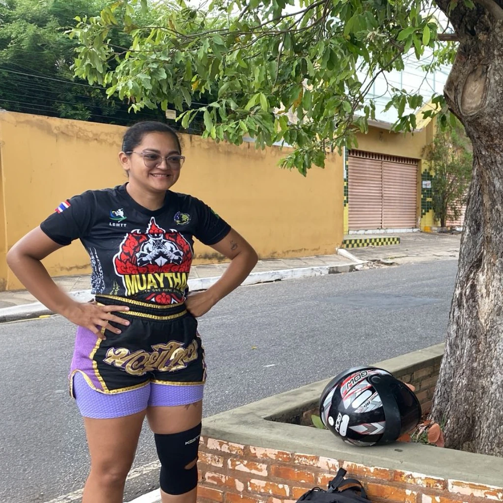 a woman that is standing next to a tree, by Nándor Katona, instagram, toyism, heroic muay thai stance pose, cycling!!, wearing knee pads, carnaval de barranquilla, wearing a tee shirt and combats, 2022, foto realista, posing for a picture