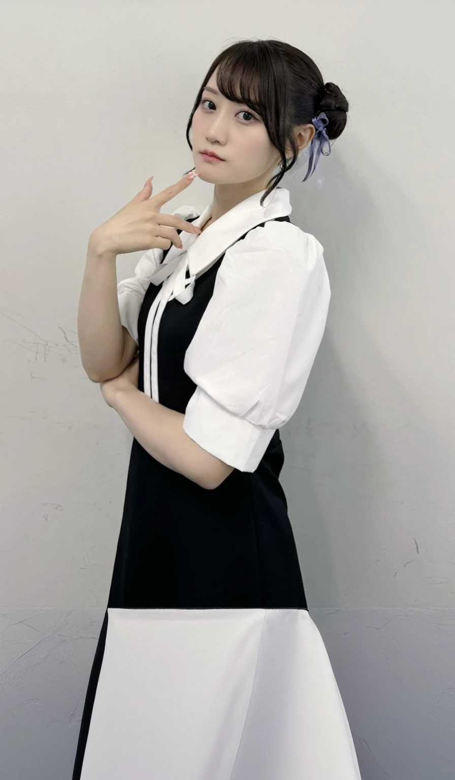 A woman in a black and white dress poses for a photo,