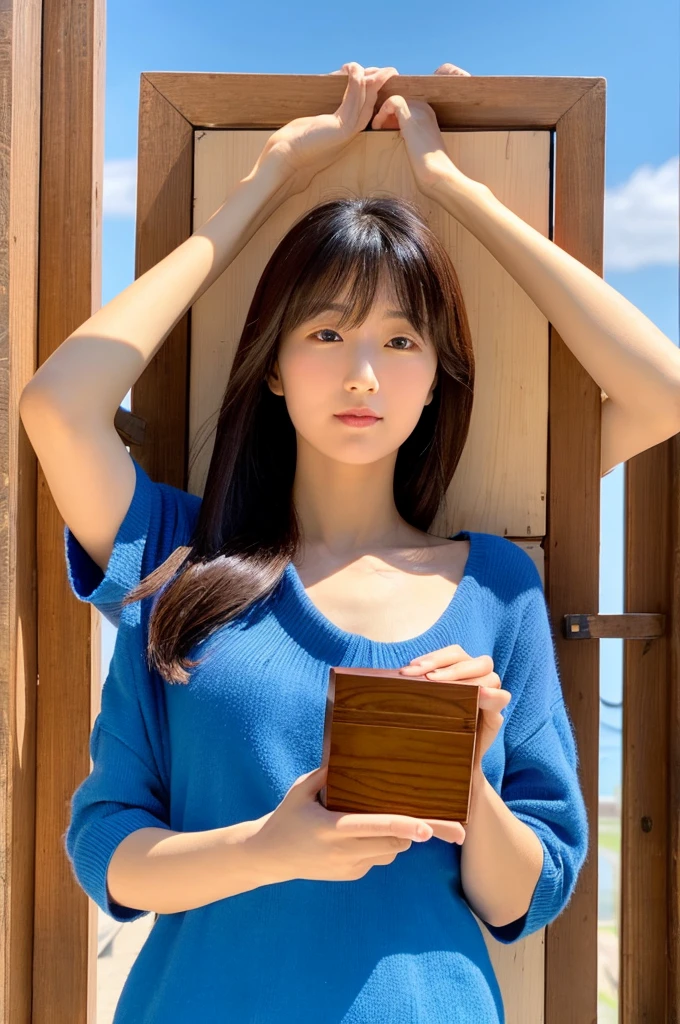 Woman holding a wooden box in the middle of her chest Blue sky