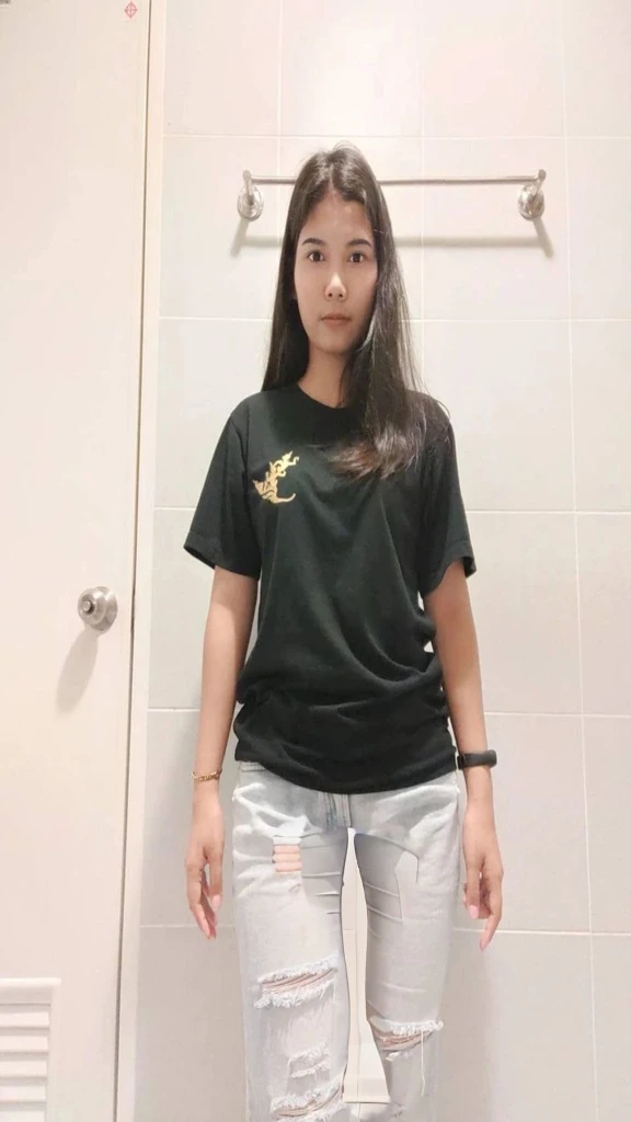 arafed woman standing in a bathroom with a black shirt and ripped jeans, wearing black tshirt, wearing a black t-shirt, wearing a black tshirt, black t shirt, black t - shirt, black t-shirt, tshirt!!, inspired by Yi Insang, 18 years old, full body picture, black shirt, wearing a black!! t - shirt, peeing her jeans.
