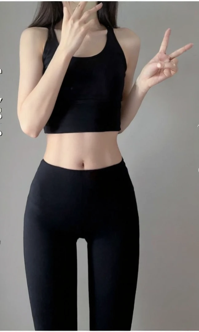 A woman in her twenties wearing a black tank top, Small waist, Narrow waist, Narrow waist, Narrow waistと太いヒップ, Slim girl photos, Slim waist, with a Narrow waist, Slim girl photos model, Very slim body, physically : The smallest abdomen ever, Fits a slender figure, The smallest abdomen ever、bedに座っている、bed、Sitting cross-legged、