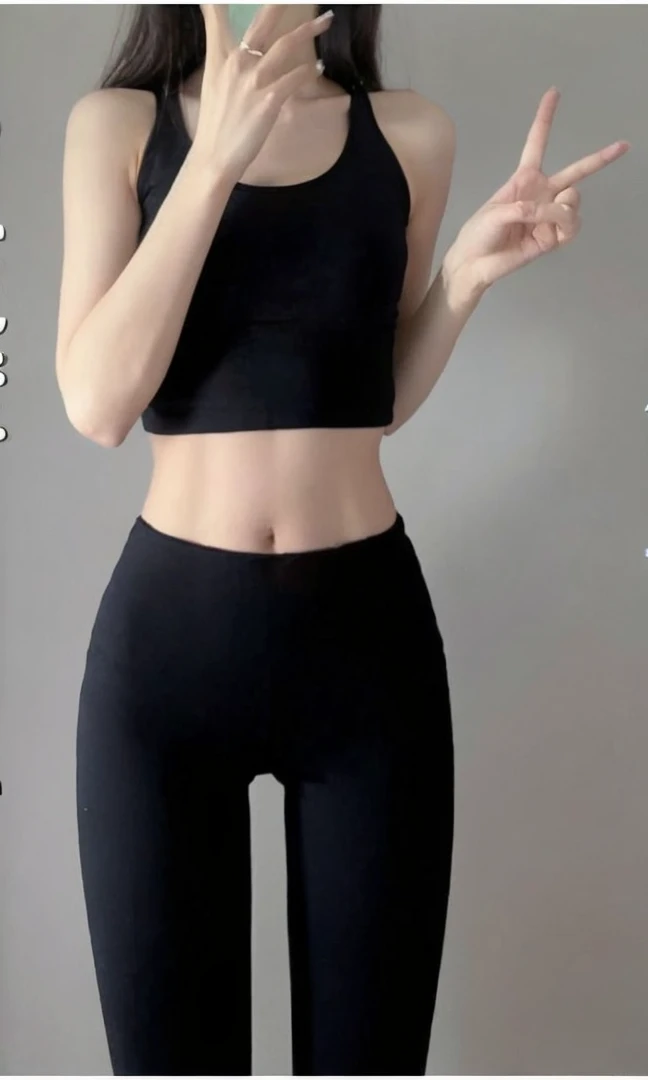 A woman in her twenties wearing a black tank top, Small waist, Narrow waist, Narrow waist, Narrow waistと太いヒップ, Slim girl photos, Slim waist, with a Narrow waist, Slim girl photos model, Very slim body, physically : The smallest abdomen ever, Fits a slender figure, The smallest abdomen ever、bedに座っている、bed、Sitting cross-legged、