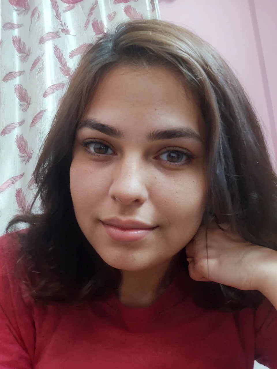 Pretty, indoor, brunette, mole on the left side of chin, smilling, sharp nose, plump full lips, big almond eyes, fair skin, arched eyebrows, square face, sharp jawline, high cheekbone, chubby, black clothes