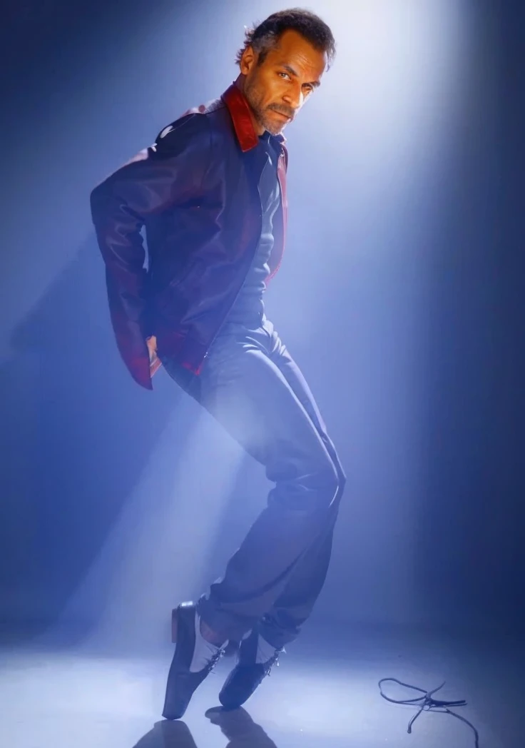 A Old Black man with receding hair line looking to left and wearing a red leather jacket and wearing a Black pants and Dancing 