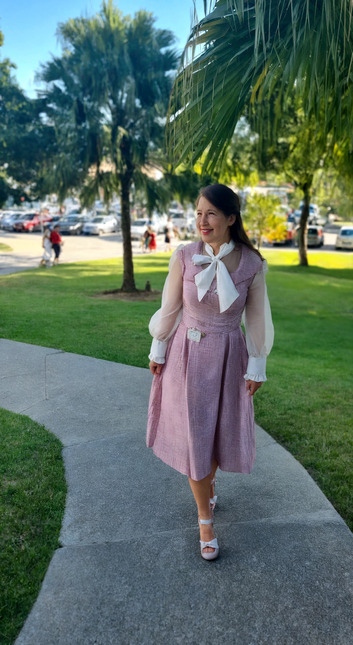 there is a woman standing on the sidewalk in a pink dress, whole body wide shot, whole body in view, very low quality image, wearing 10s era clothes, Old dress, outfit photo, front side full, dressed like in the 1940s, It is cute, whole body picture, outdoor photo, whole body!