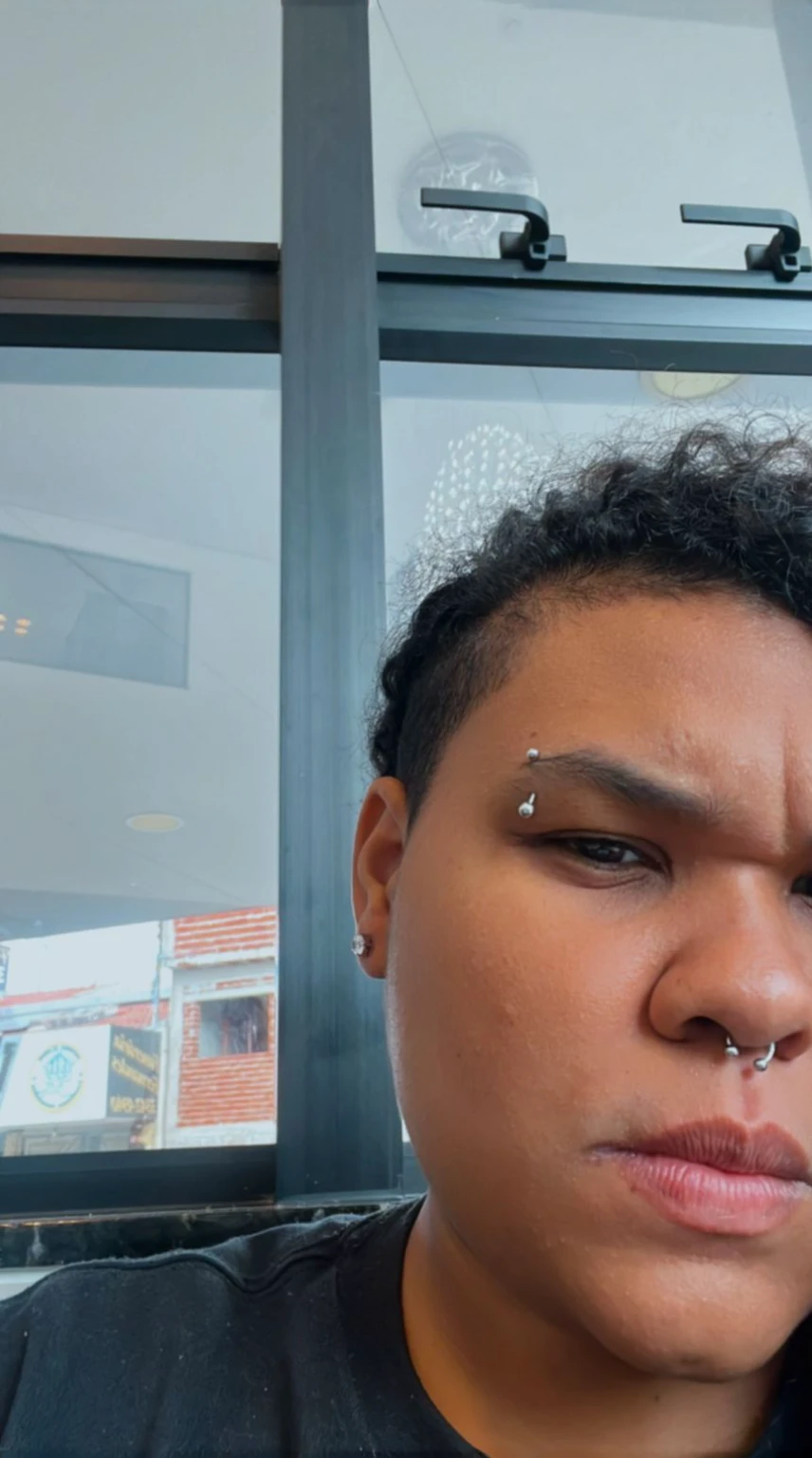 There is a woman with a piercing on her forehead, using spikes and piercings, piercing look, piercings e um moicano, androgynous face, piercing de septo, huge earrings and strange makeup, face piercings, with anxious and penetrating eyes, no facial features, olhos castanhos brilhantes e penetrantes, chrome face piercings, face piercings, face detailed!