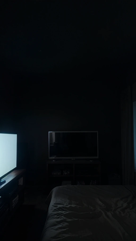 A simple room with a TV playing a movie, the room is very dark at night, the view from the bed to the TV