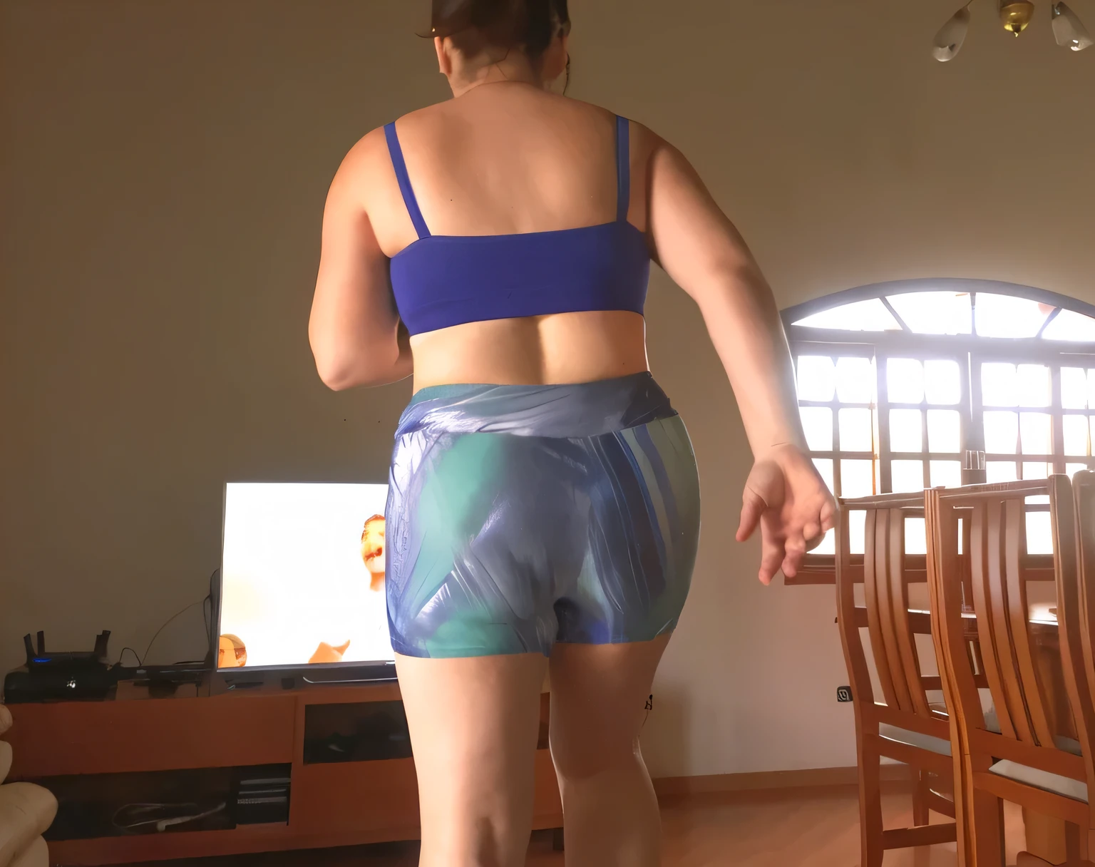 there is a woman in a blue bra top and blue shorts, view from the back, seen from the back, middle shot waist up, toned derriere, rear-shot, view from behind, from the back, backview, long shot from the back, shapely toned derriere, shot from the back, shapely derriere, from back