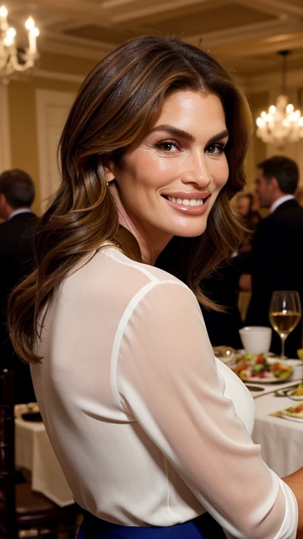 Cindy Crawford dressed in attractive lady's clothes at a dinner with a smile