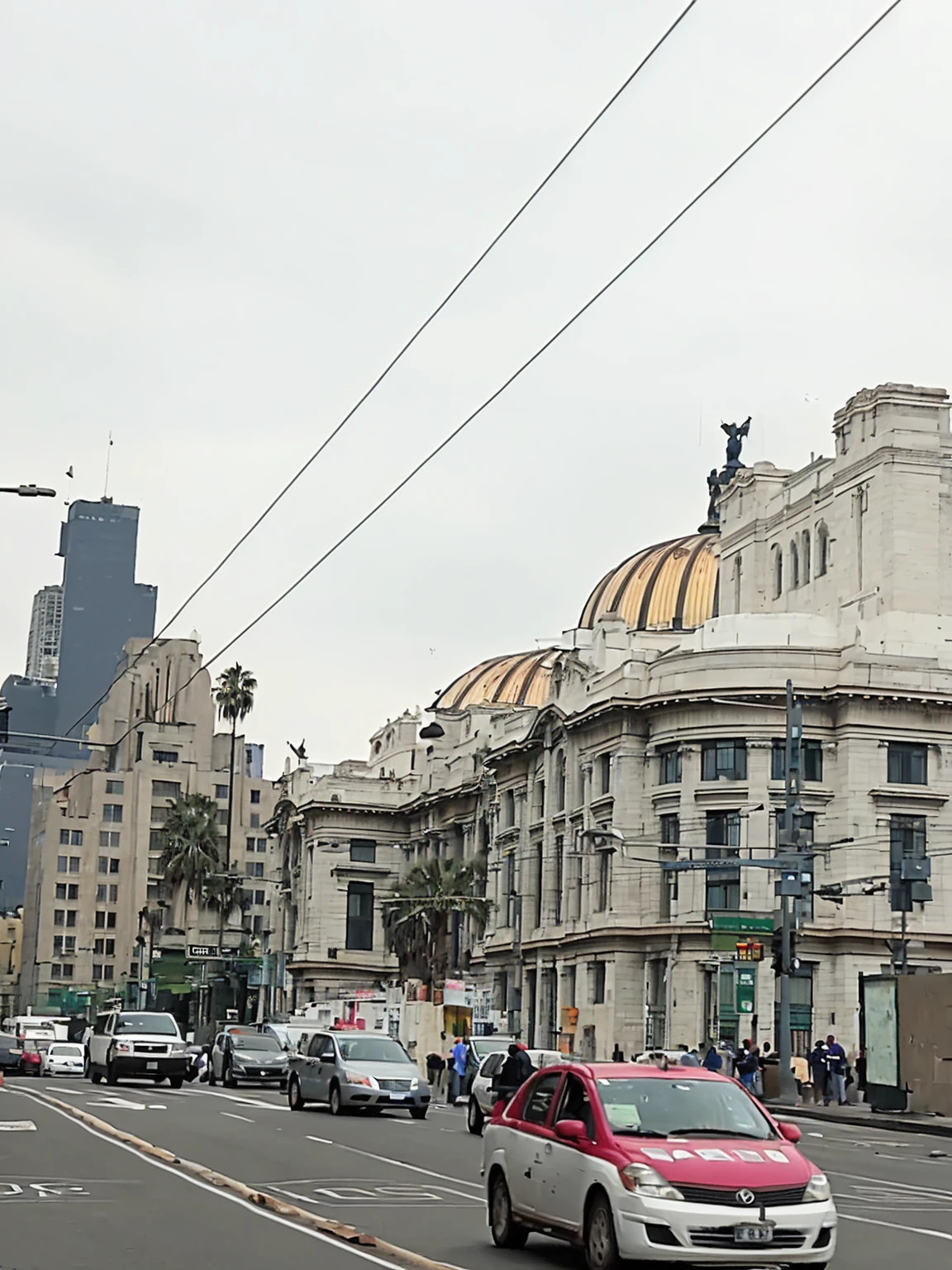 Cars drive on a city street with a building in the background., center mexico, Mexico City, surrounding the city, View from across the street, Lots of construction, edificios épicos en el center, in a city with a rich history, View from the streets, center, Lots of constructions, Big buildings, Building in the distance, white marble buildings, seen from outside, HD, 4k, Good Quality