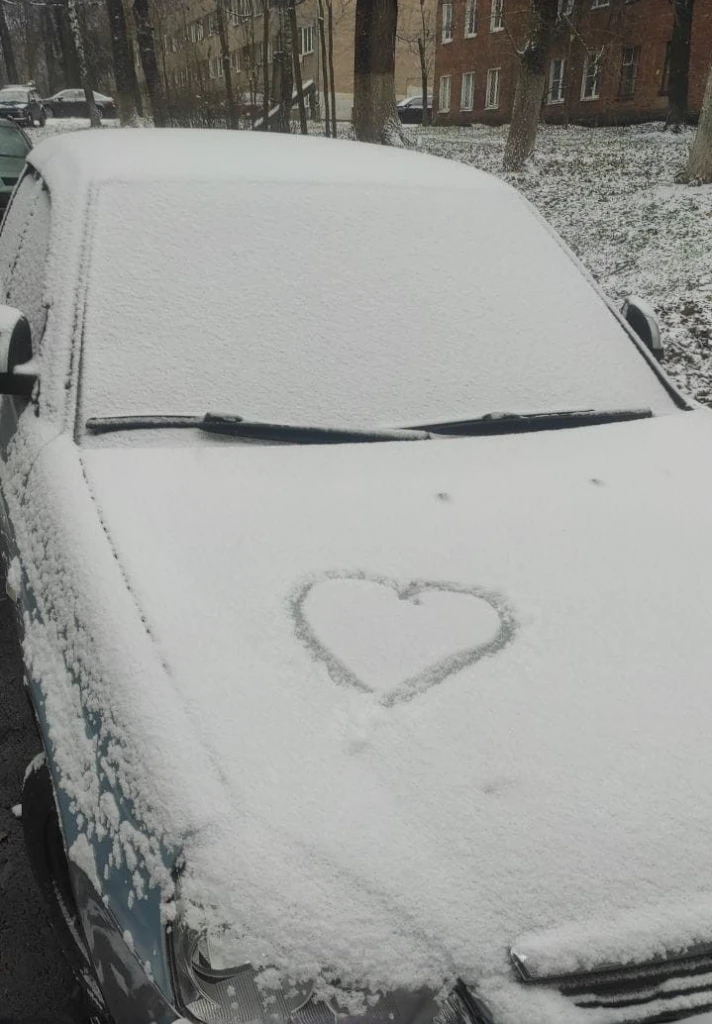 Replace the heart drawn with snow on the hood of the car with the word fabi