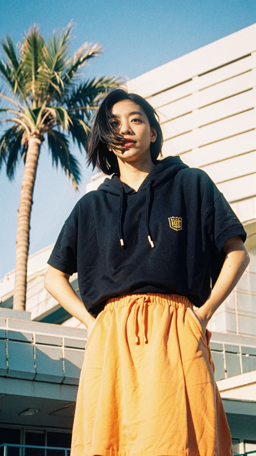 Best Quality,Masterpiece,Ultra High Resolution,(Realisticity:1.4),Original Photo, 1Girl,1 girl, wear ((orange color oversized hoodie)), (purple tennis skirt), light leak,dark intens shadow,ultra high resolution,UHD,beautiful, black bob hair, almond eye, no makeup, in front of 80's architecture colorful motel, (from below:1.2), (realistic:1.2), (surreal:1.3), (very detailed:1.1), ((masterpiece)),summer, blue sky, (palm trees),sunny, los angles vibes,thick outline. blurry photo. color slide film. 1958