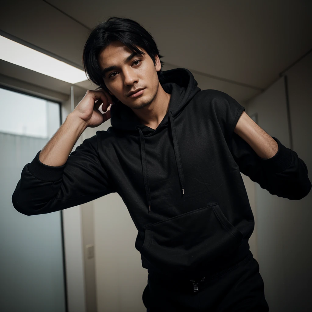 Man wearing black hoodie, black pants, black hair, looking up 