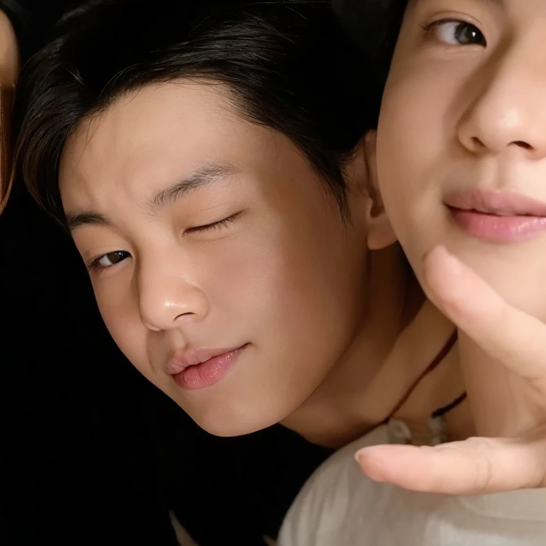 an asian boy in a room winking