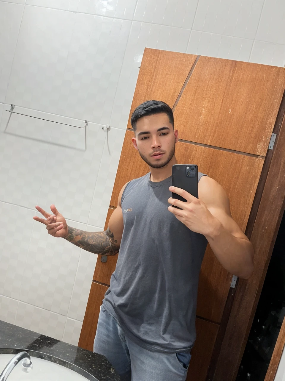 a beautiful 25 year old gamer boy (Deivid Burch:0.5), (((skin texture:1))), ((natural skin)), (black hair), (pale skin), strong body, (high detail low cut white tank top with logo), (shorts jeans), sitting at PlayStation, gaming, headset, widescreen, (masterpiece) (perfect proportion)(realistic photo)(best quality) (detailed) shot on a Canon EOS R5, 50mm lens, F/2.8, HDR, (8k) (wallpaper) (cinematic lighting) (gamer lighting) (sharp focus) (intricate), RAW photo, posing for camera, 8k uhd, dslr, high quality, film grain, shot by Arny Freytag