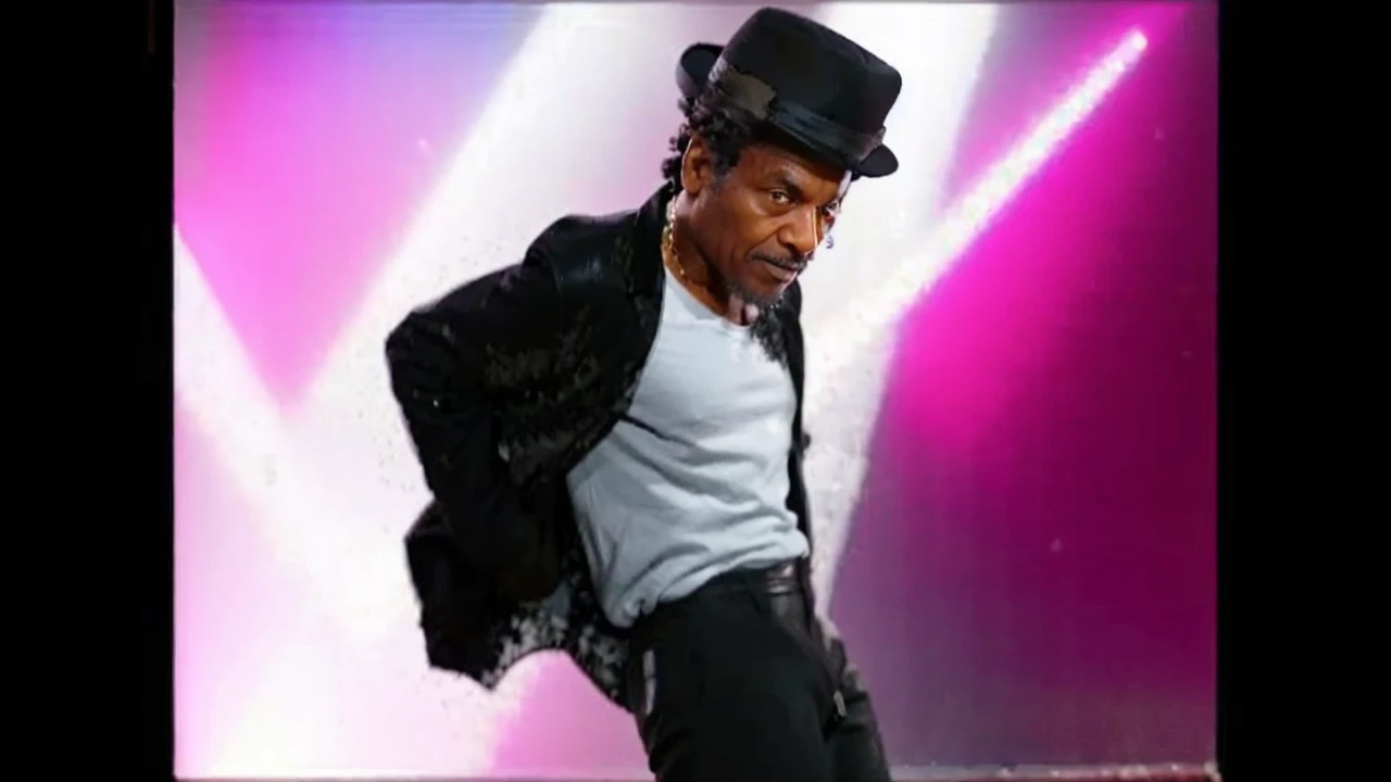 A Old Black man with receding hair line looking to left and wearing a Black Glitter jacket and wearing a Black pants with line and wearing a Black hat And Dancing on Floor