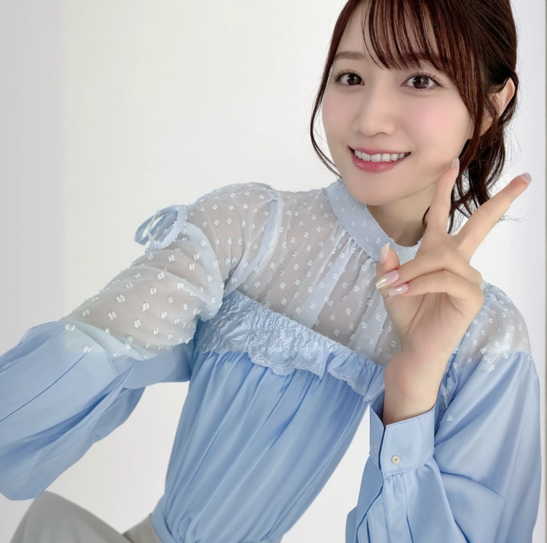 There is a woman making a peace sign and taking a photo.,Blue blouse、