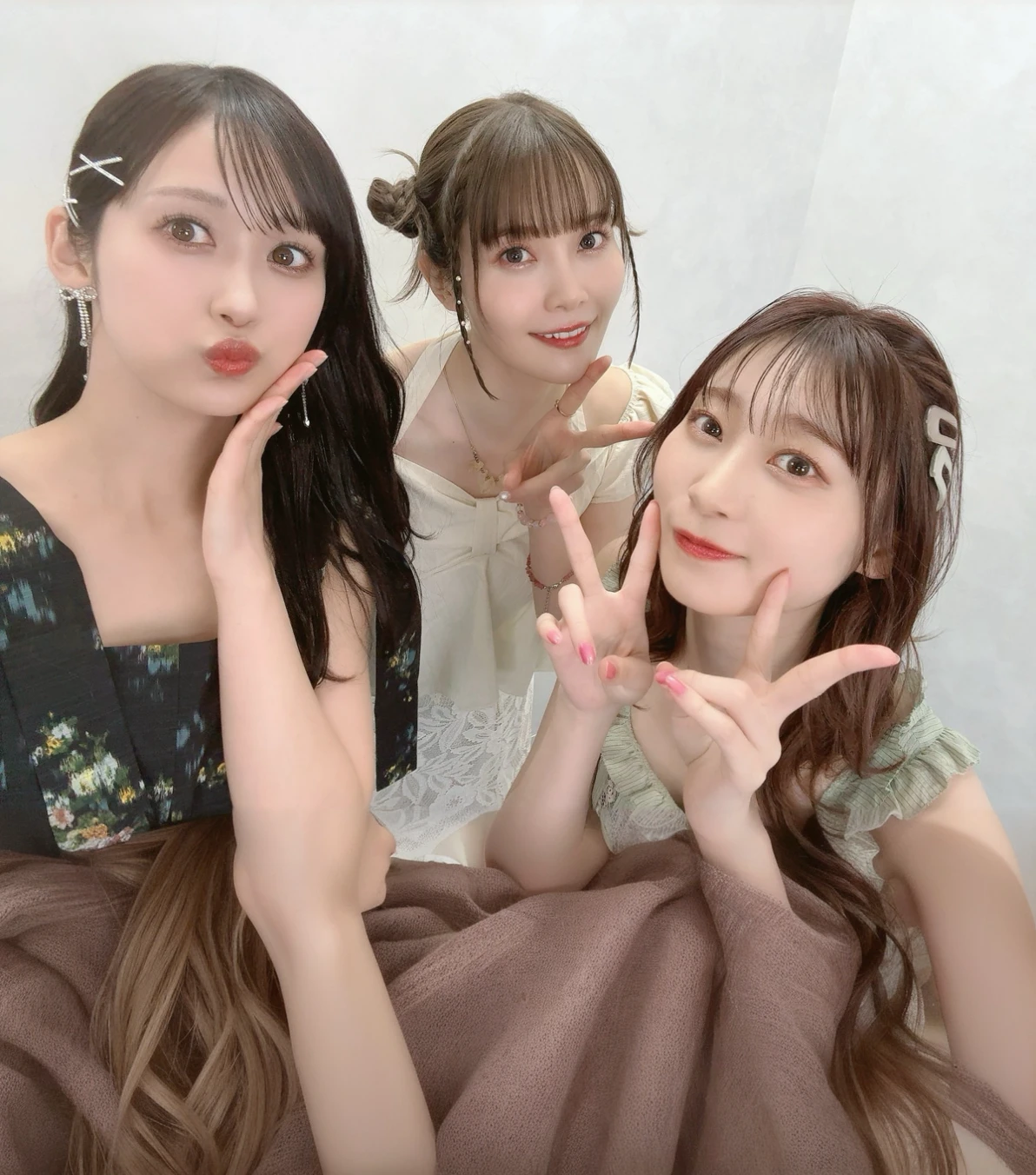 Three women posing in front of the camera、dress、