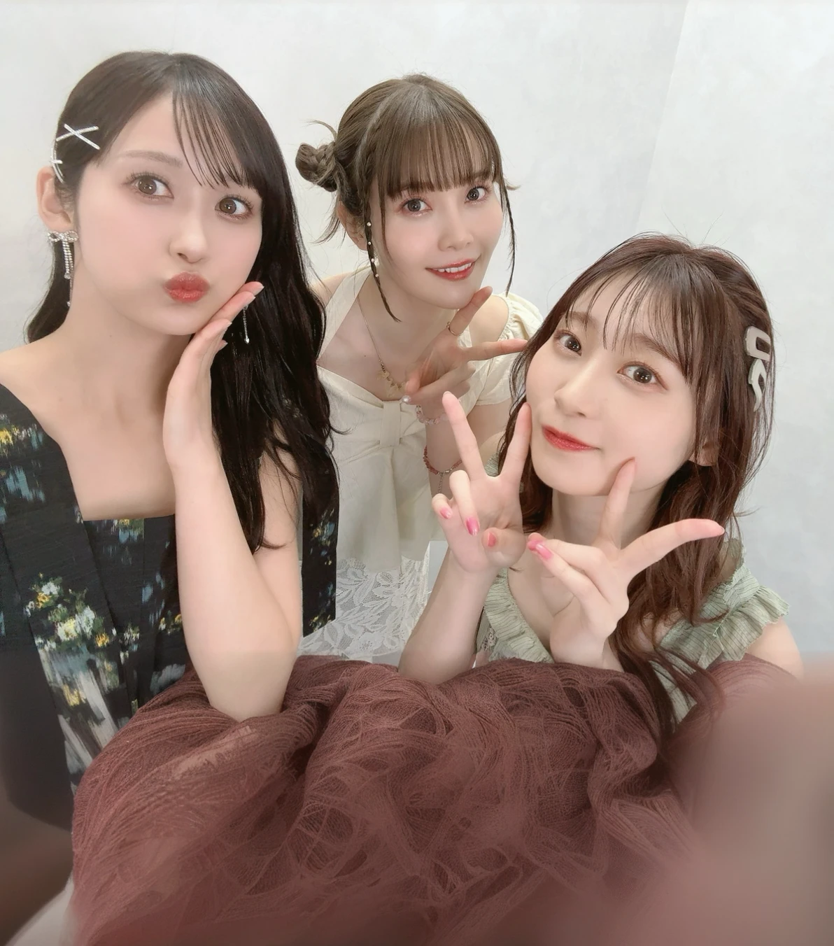 Three women posing in front of the camera、dress、