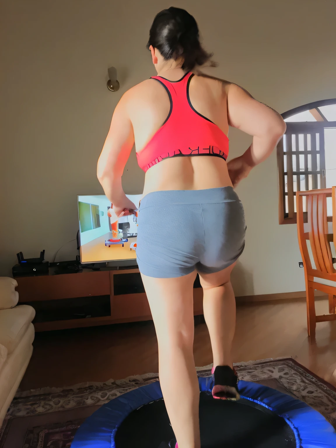 there is a woman in a pink top and gray shorts on a trampoline, long shot from the back, rear-shot, shot from the back, from back, view from the back, long shot from back, from the back, working out, back view!!, back arched, toned derriere, back - shot, back shot, back pose, rear shot