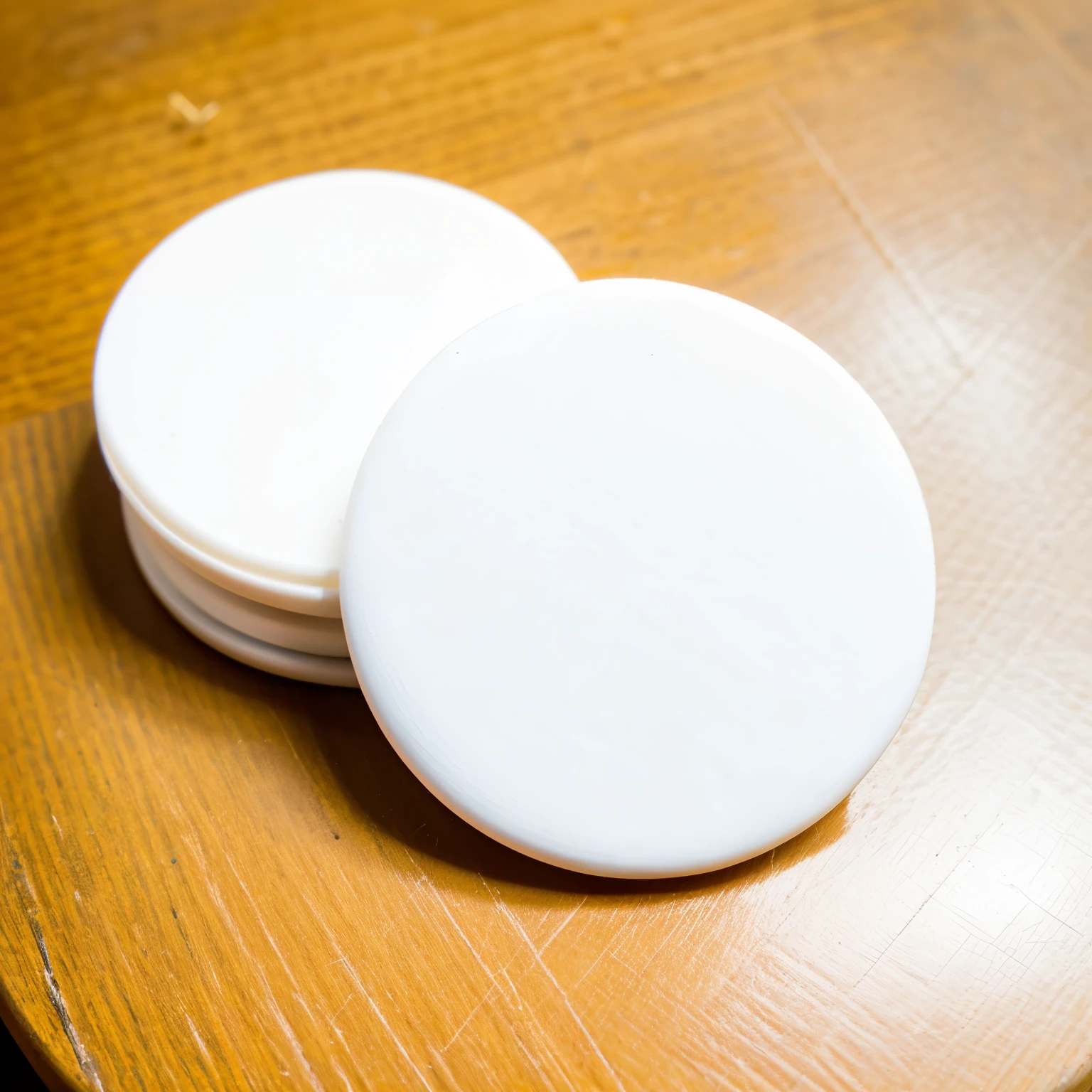 Model: of a round white advertising pin, on top of a desk