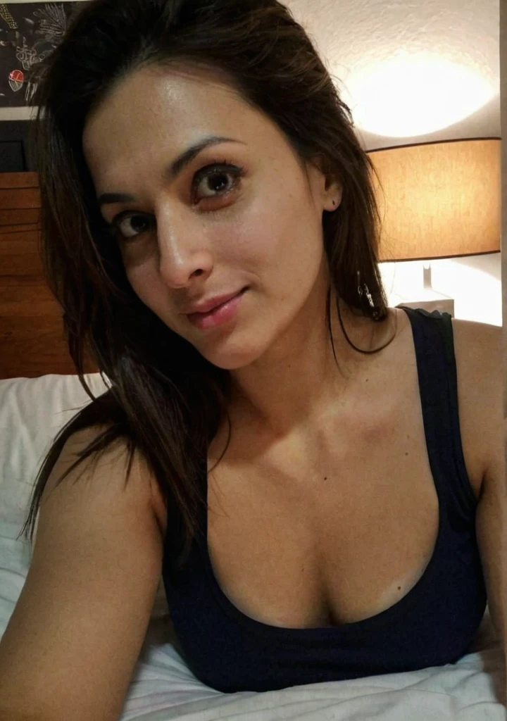 iphone night mode photo, pretty punjabi mom, fair white skin, lying in bed, takig selfie, at night, in a low neck tank top, low light, dark photo, dimly lit, extreme close-up