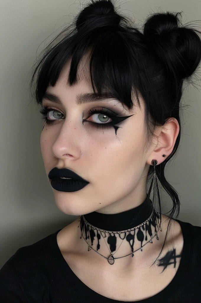 a person with a unique alternative aesthetic. They have dark hair styled with two buns on the top of their head and straight bangs across their forehead. The individual's eyes are a soft green, and they wear dramatic black lipstick. They have a septum piercing and multiple earrings in one ear. Their makeup is notable for the winged eyeliner, and there are artistic black streaks or smudges on their right cheek, adding an edgy touch. They wear a black t-shirt with a graphic design visible at the neckline, and their look is accessorized with a black choker and layered necklaces. The backdrop has a marbled or mottled texture in grayish tones, which complements the dark hues of their outfit and makeup.  g0thg1rl