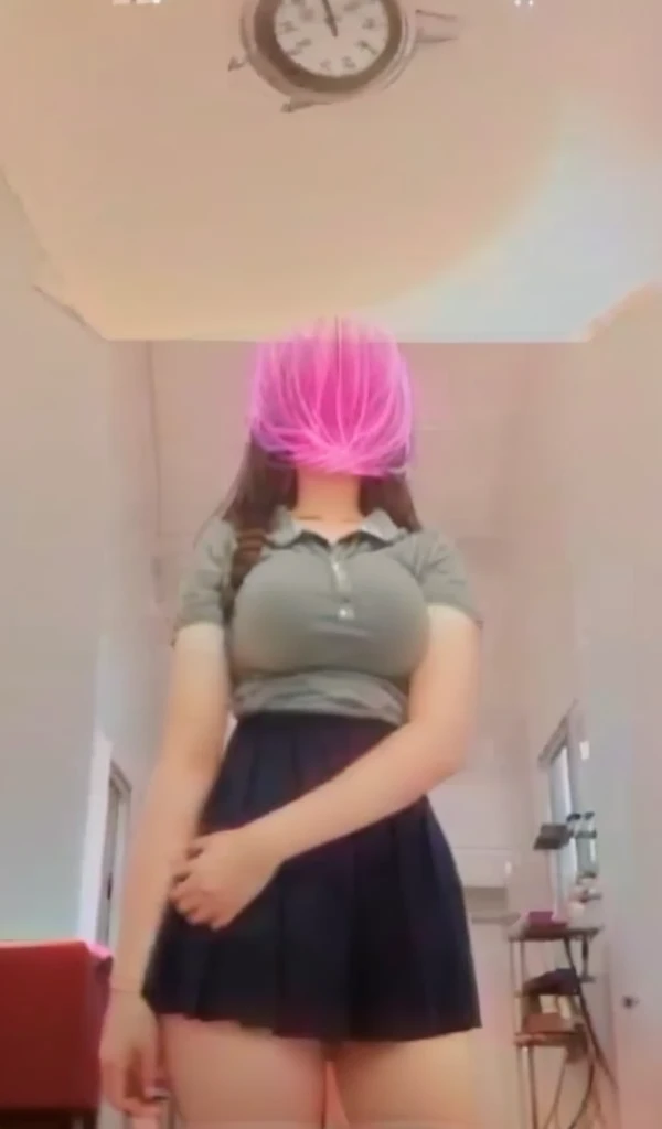 A 13 year old girl wears a skirt that is too short to show her genitals and has large breasts.
