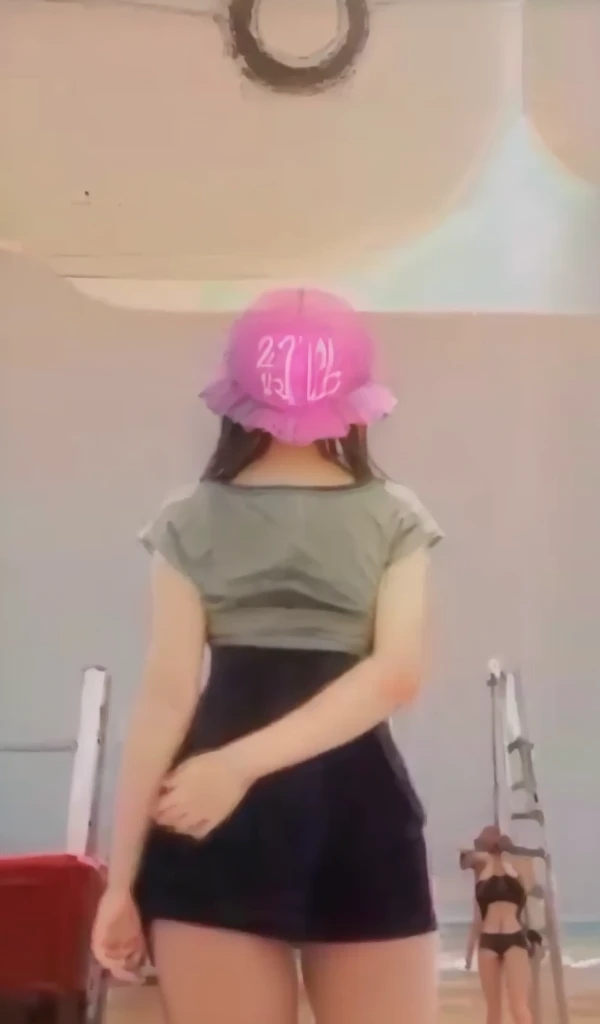 A 13 year old girl wears a bikini at the beach and has large breasts.