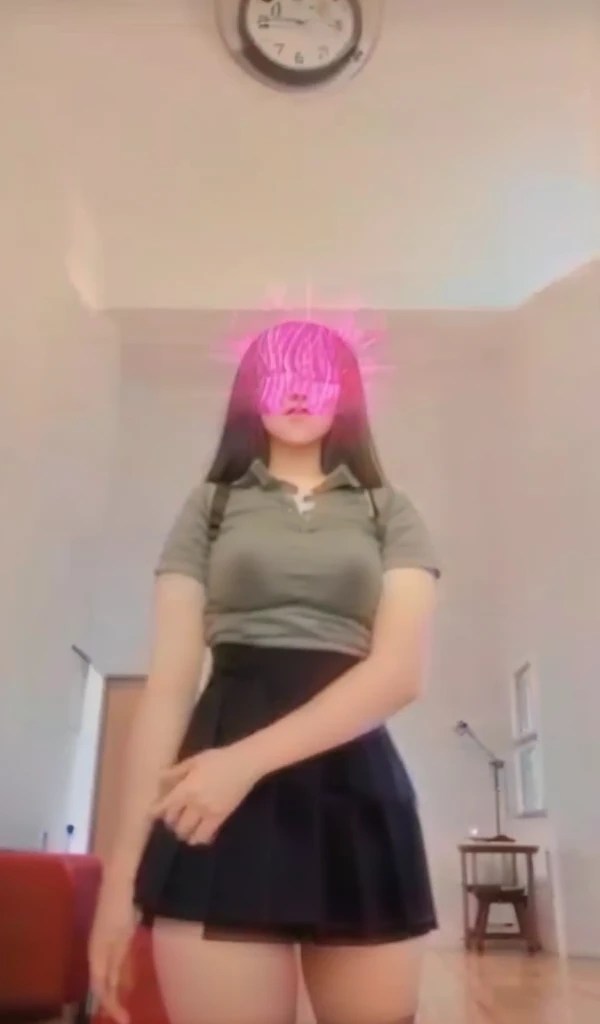 A 13-year-old woman wears a short skirt and black stockings and has A-cup breasts.